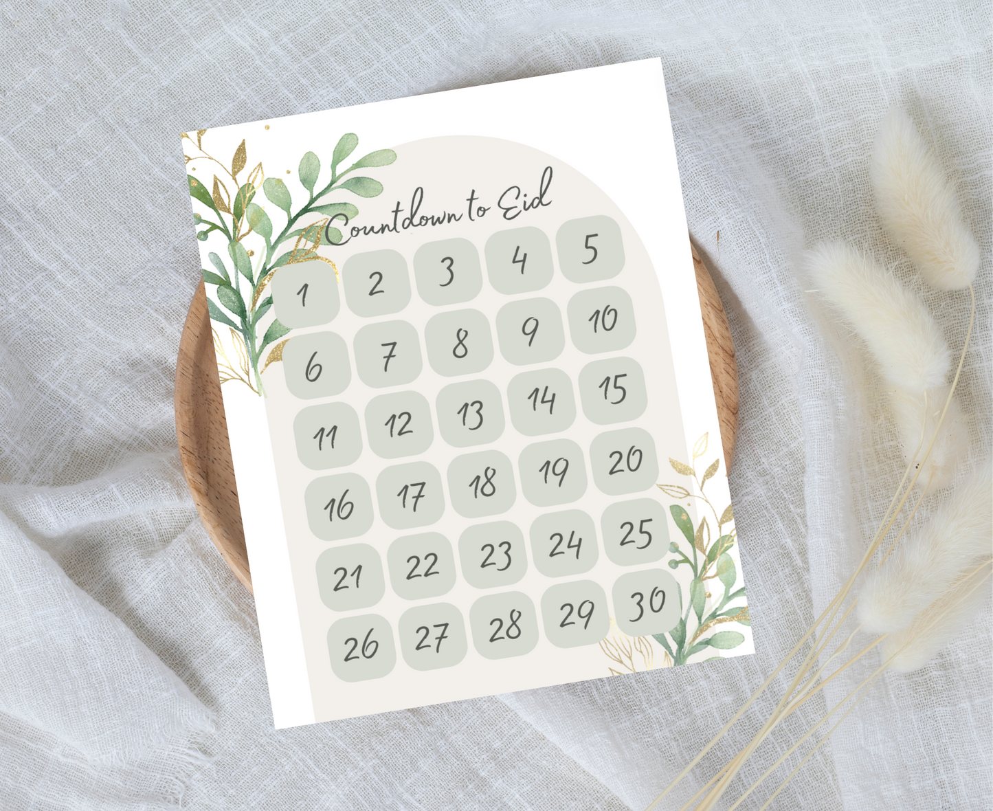 Countdown to Eid print on a neutral cloth background and round wooden tray.