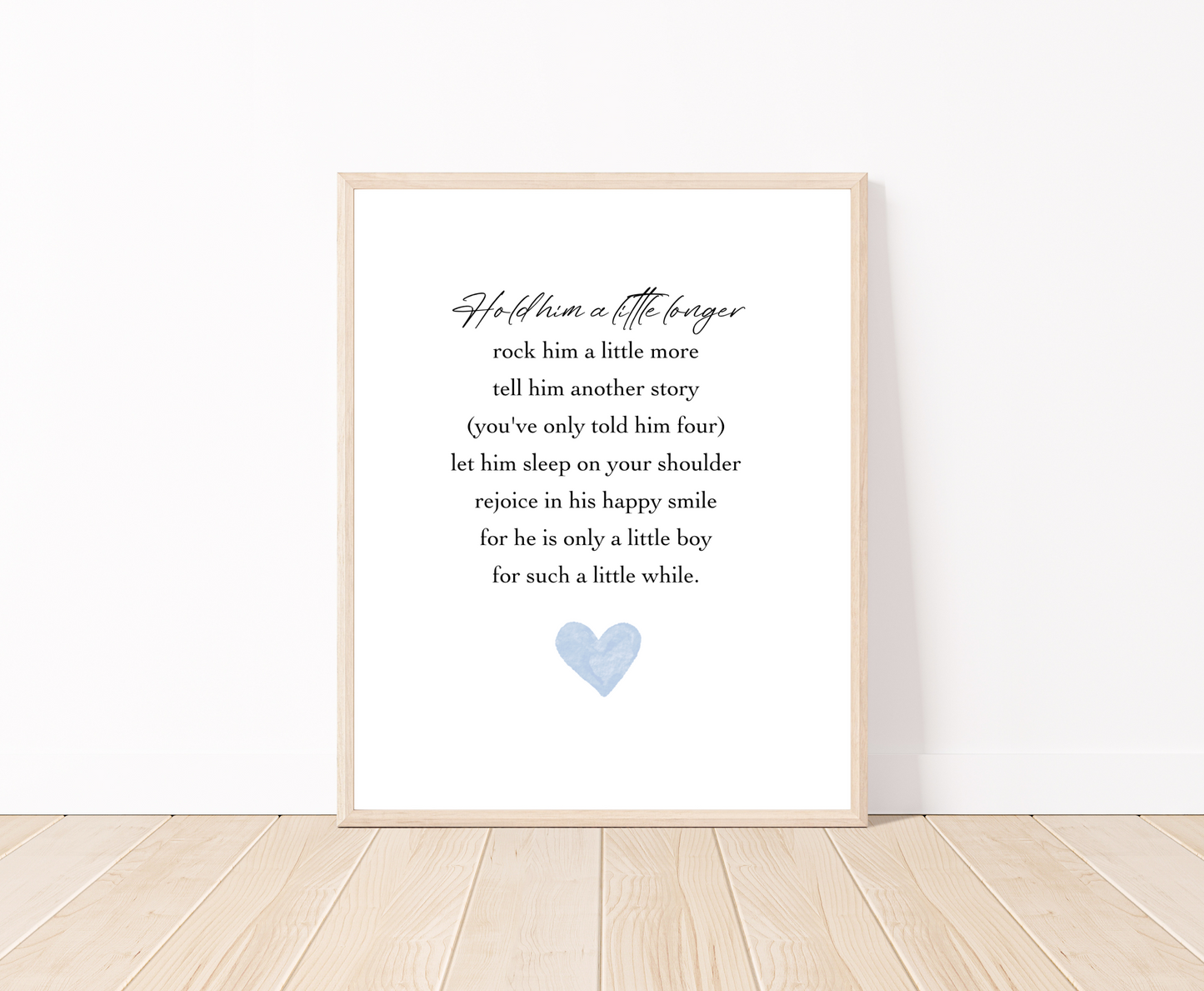 A digital poster placed on a white wall and parquet flooring that has a blue heart at the bottom, and a piece of writing above it that says: Hold him a little longer, rock him a little more, tell him another story, (you have only told him four), let him sleep on your shoulder, rejoice in his happy smile, for he is only a little boy, for such a little while.