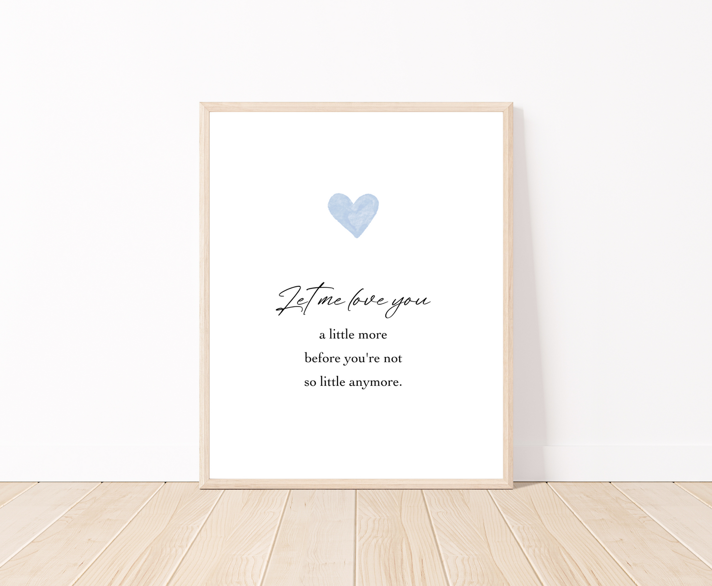 A digital poster is placed on a white wall and parquet flooring and has a blue heart at the top with a piece of writing that says: “Let me love you, a little more before you’re not so little anymore.”