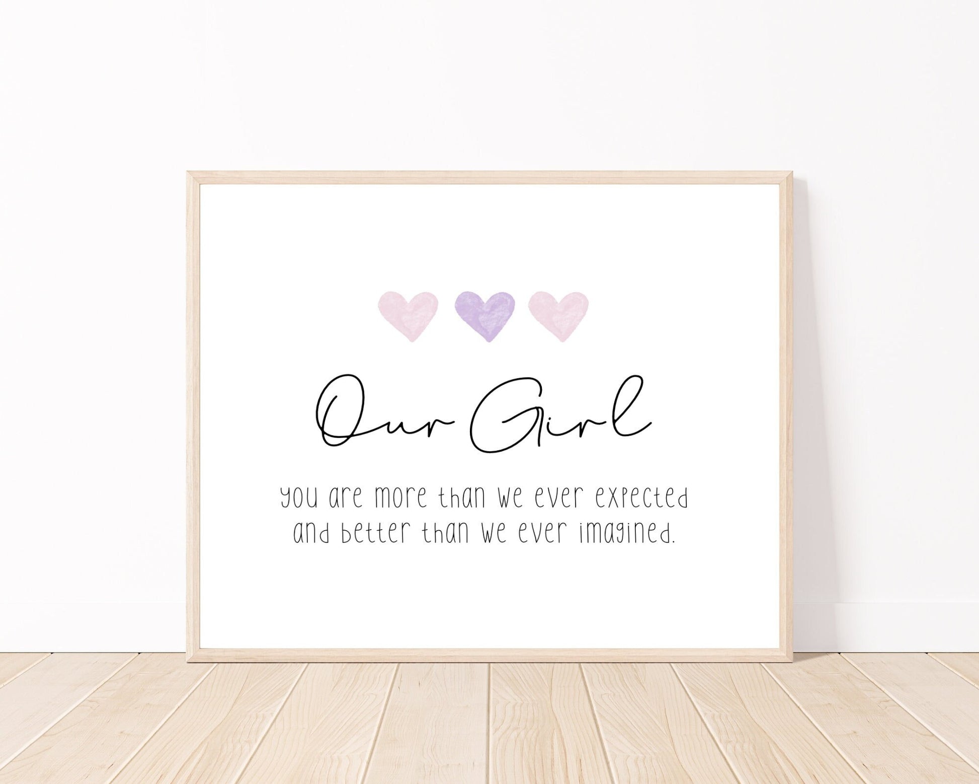 A little girl’s graphic showing three baby pink and purple hearts with a piece of writing below that says: Our girl, you are more than we ever expected, and better than we ever imagined.