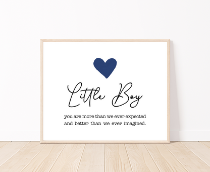 A frame displaying a dark blue heart with a piece of writing below that says: Little boy, you are more than we ever expected and better than we ever imagined.
