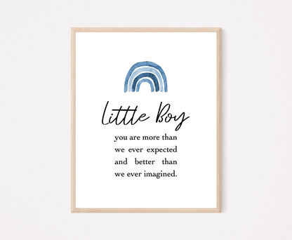 A frame showing a graphic for a little boy’s room displaying a rainbow design in different shades of blue and includes a piece of writing that says: Little boy, you are more than we ever expected and better than we ever imagined.