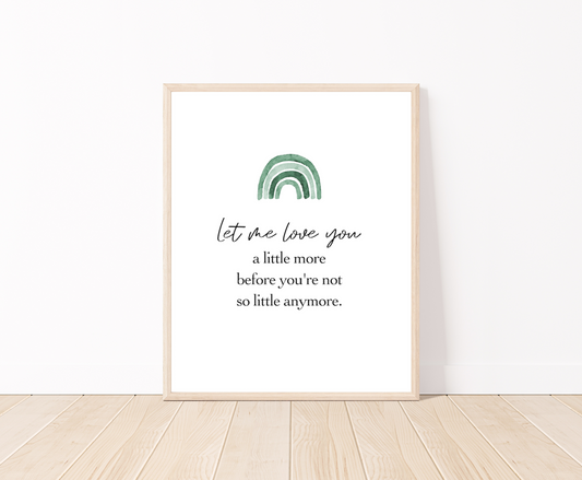 A digital placed on the floor showing a green ombre rainbow on top with a piece of writing below saying: let me love you a little more before you are not little anymore. 