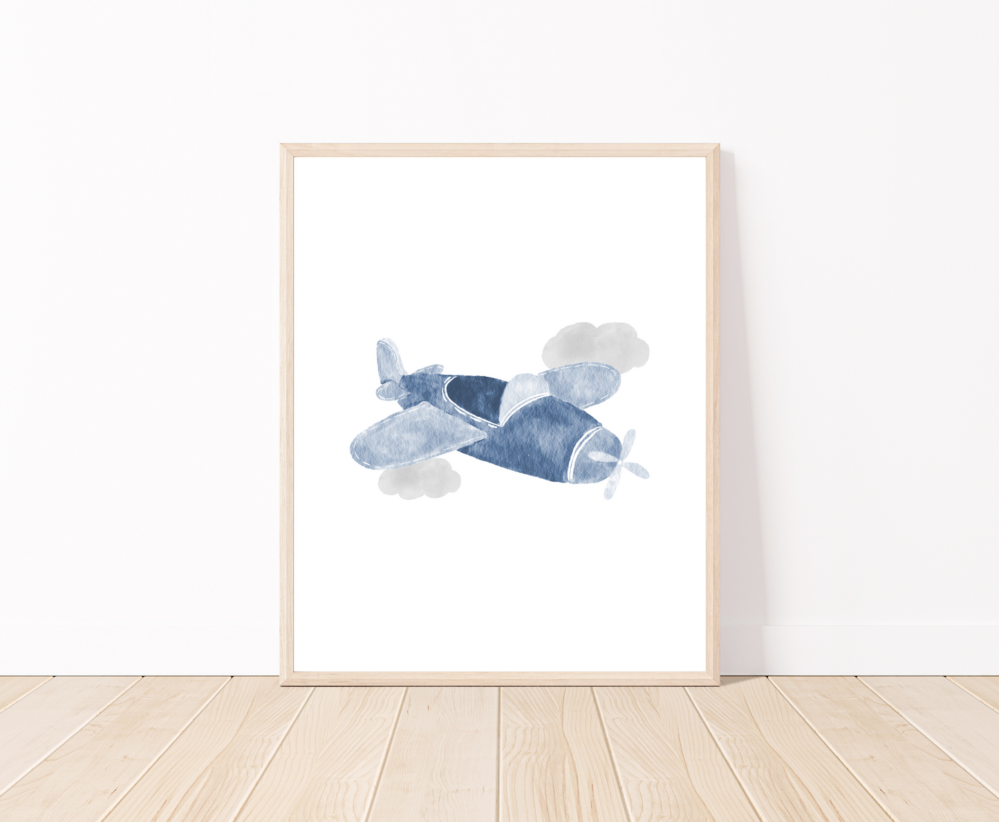 A digital poster is placed on a white wall and parquet flooring and shows a baby blue airplane and two gray clouds.
