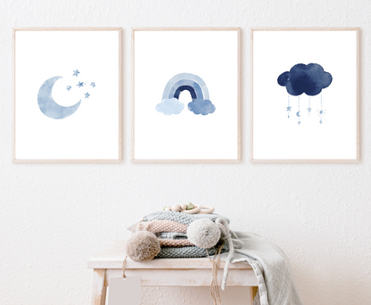 Three frames showing blue graphics that are hung on a white wall. The first one shows a blue crescent moon with tiny blue stars right beside it. The second one shows a rainbow in different shades of blue. The third frame shows a dark blue cloud with tiny blue crescent moons and stars dangling from it.