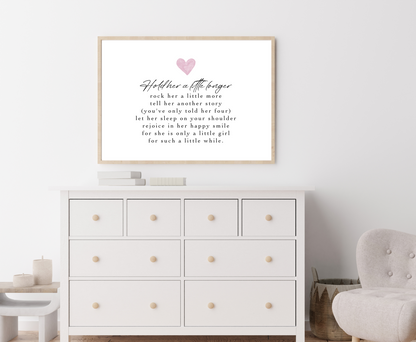 A digital print is placed above a nursery wardrobe. The digital print has a pink heart at the top and a piece of writing that says: Hold her a little longer, rock her a little more, tell her another story, (you have only told her four), let her sleep on your shoulder, rejoice in her happy smile, for she is only a little girl, for such a little while.