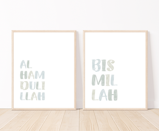Two digital prints for a little boy’s room that are placed on a white wall and parquet flooring. The first one includes “Alhamdulillah” written in upper case and multi-colored letters with a white background. The second one includes “Bismillah” written in upper case and multi-colored letters with a white background.