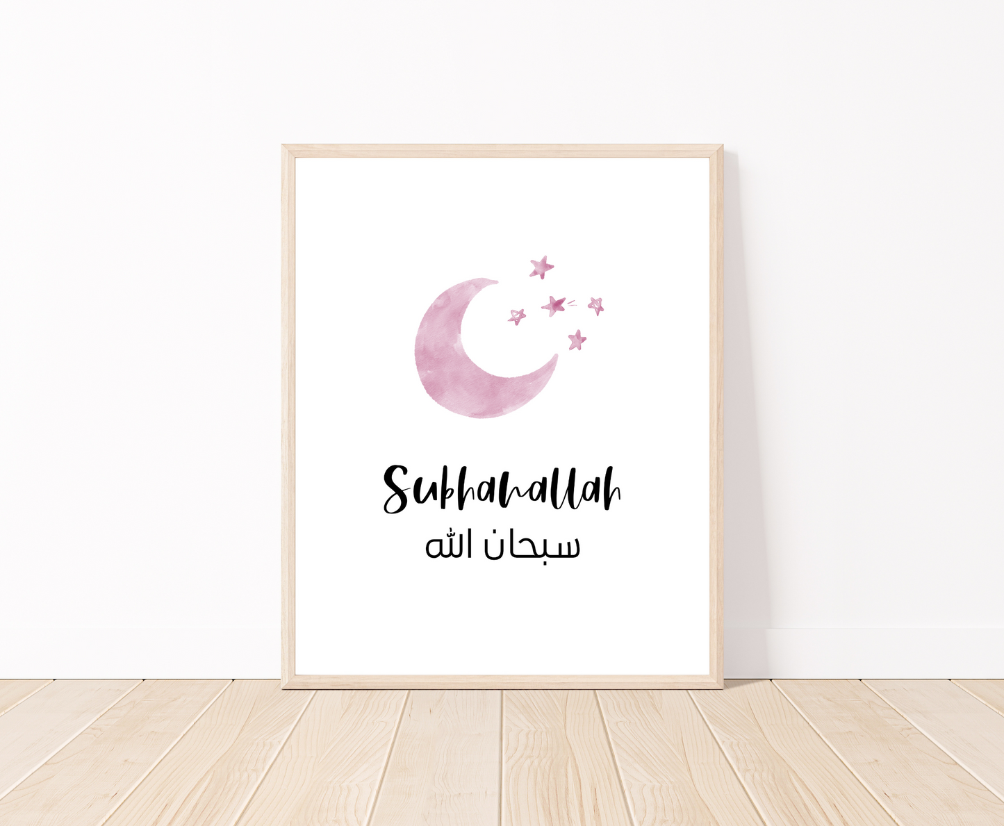 A digital print placed on a white wall and parquet flooring showing a small pink moon and three small stars with a piece of writing below that says: “Subhanallah”.