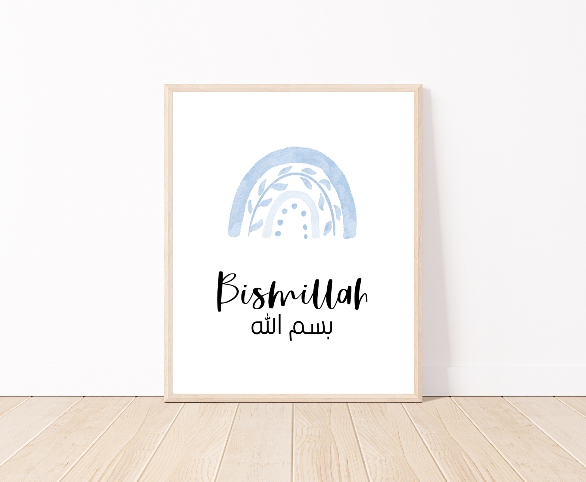 A digital print placed on a white wall and parquet flooring showing a blue rainbow with a piece of writing below that says: “Bismillah”.