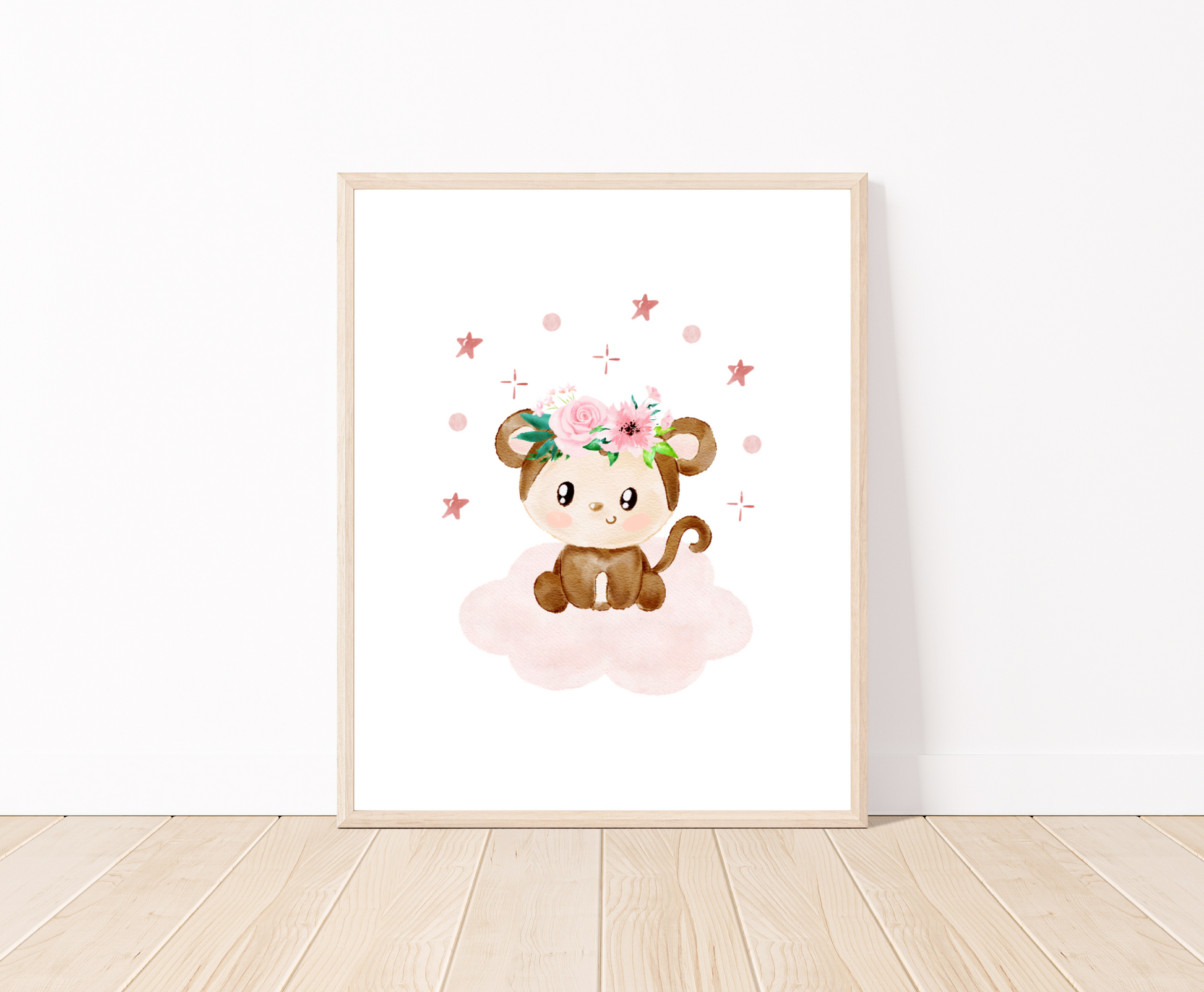 A digital print placed on a white wall and parquet flooring showing a design for a cute baby monkey that has a flower crown on its head and is sitting on a pink cloud with mini stars surrounding its head 