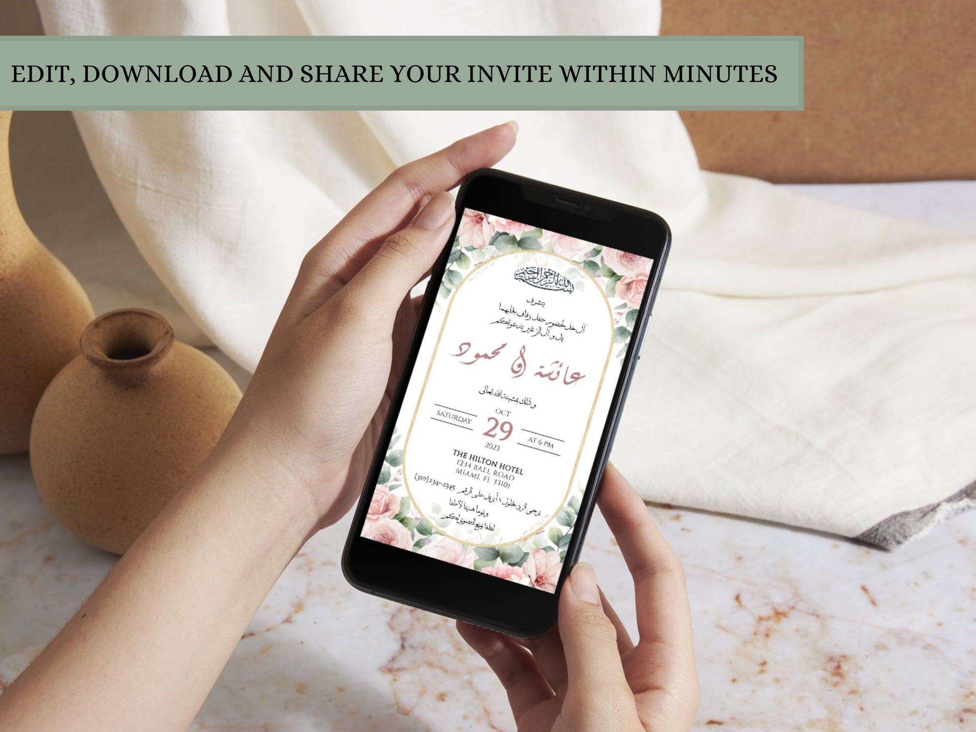 Hand holding Arabic wedding invitation card on phone. 