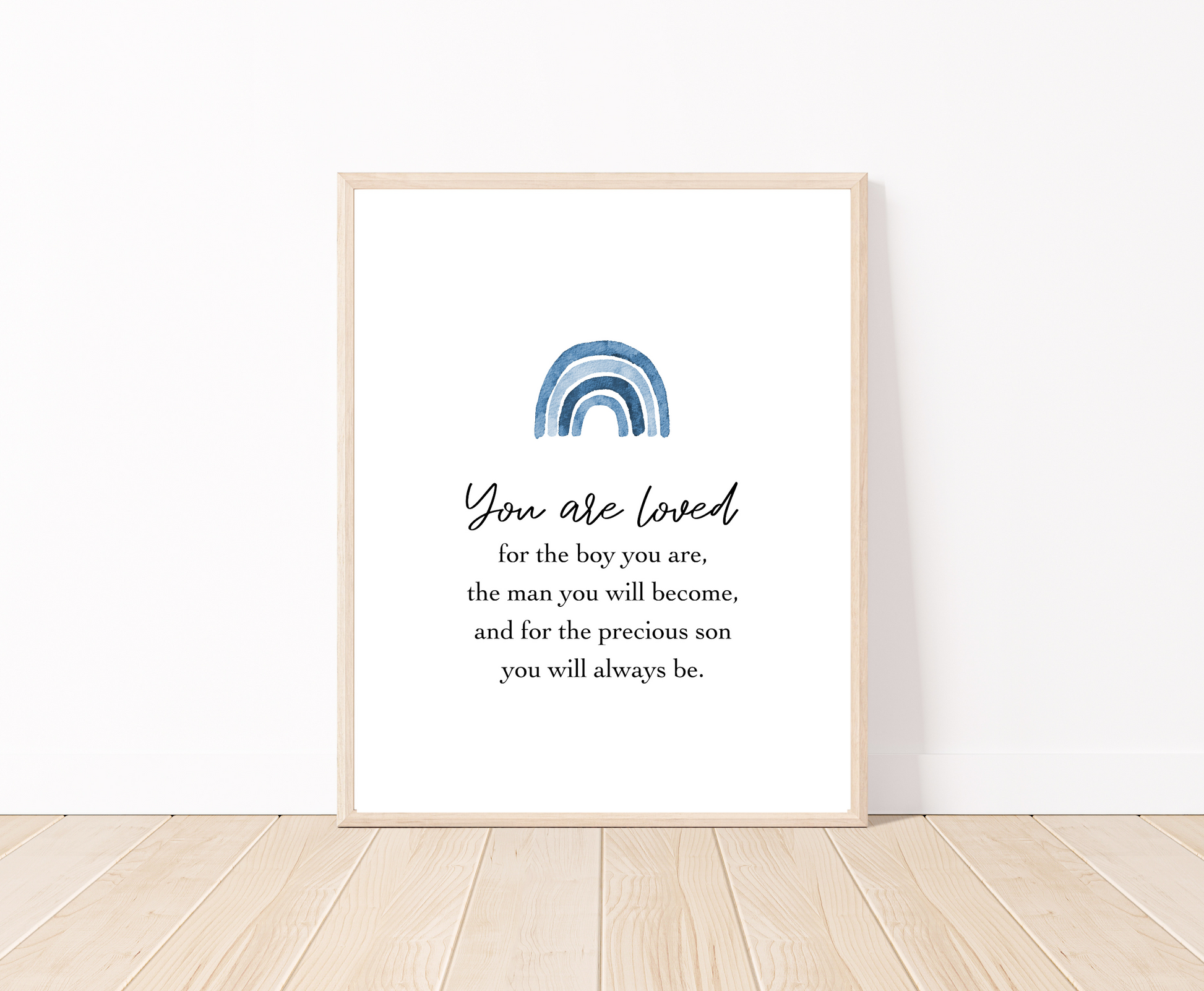 A frame showing a graphic for a little boy’s room that has a blue ombre rainbow design and includes the following “You are loved, for the boy you are, the man you will become, and for the precious son you will always be.”