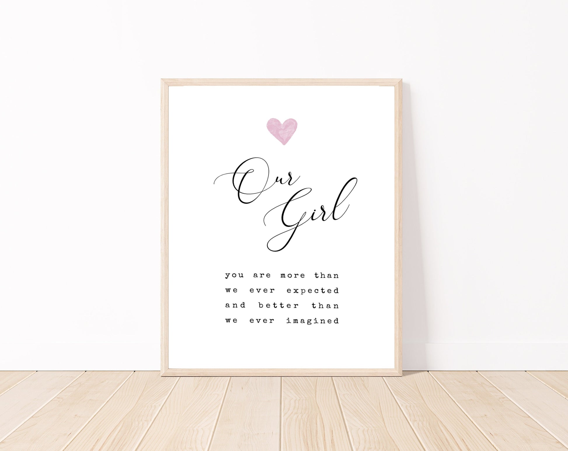 A little girl’s room digital print placed on a white wall and parquet flooring that has a pink heart at the top: one pink and two light brown, and a piece of writing that says: “Our girl, you are more than we ever expected and better than we ever imagined.”