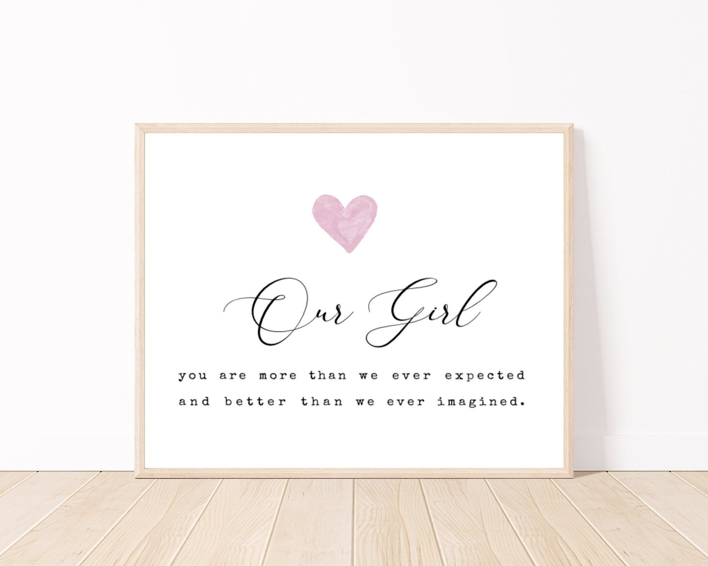 A little girl’s room digital print placed on a white wall and parquet flooring that has a pink heart at the top, and a piece of writing that says: “Our girl, you are more than we ever expected and better than we ever imagined.”