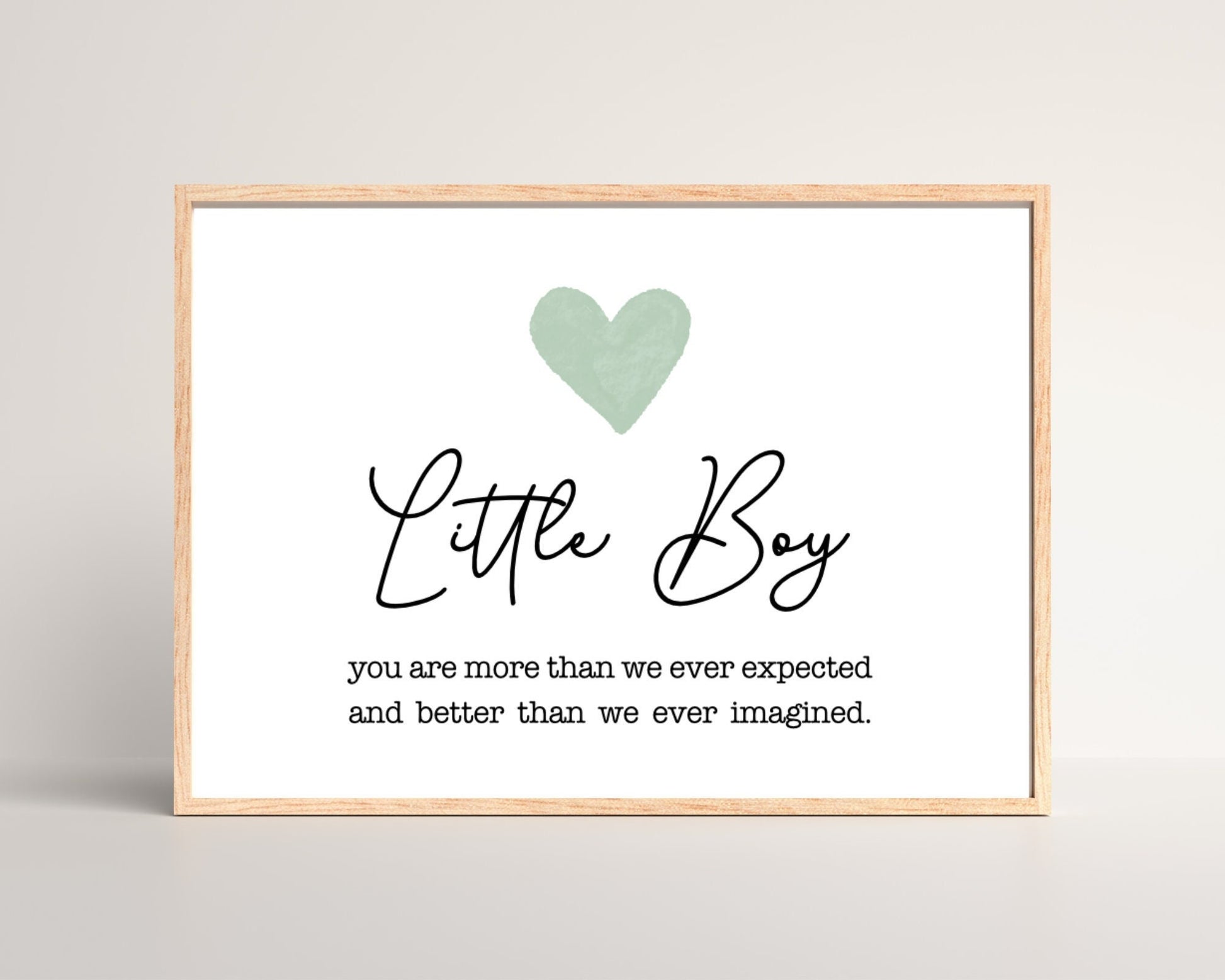A digital poster placed on a white wall and parquet flooring that has a green heart at the top, and a piece of writing that says: “Little boy, you are more than we ever expected and better than we ever imagined.”