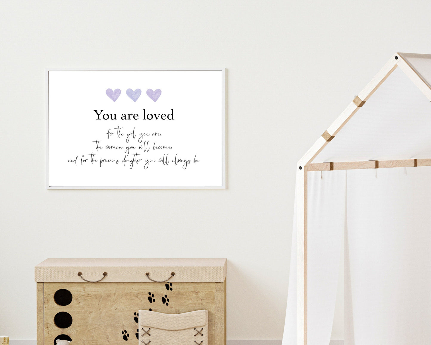 A little girl’s room digital poster that is hung on a wall and has three purple hearts at the top with a piece of writing that says: “You are loved for the girl you are, the woman you will become, and for the precious daughter you will always be.”
