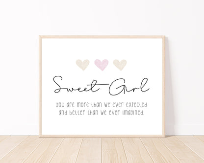 A little girl’s graphic showing three baby pink and beige hearts with a piece of writing below that says: Sweet girl, you are more than we ever expected, and better than we ever imagined.