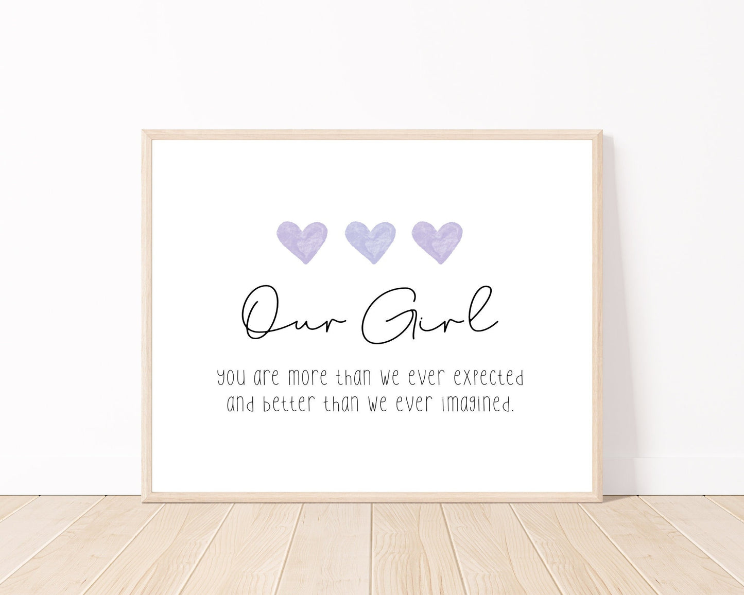 A little girl’s room digital print placed on a white wall and parquet flooring that has three purple hearts at the top, and a piece of writing that says: “Our girl, you are more than we ever expected and better than we ever imagined.”
