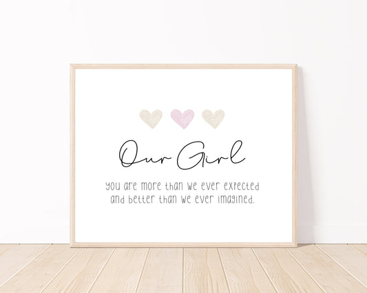 A little girl’s room digital print placed on a white wall and parquet flooring that has three hearts at the top: one pink and two light brown, and a piece of writing that says: “Our girl, you are more than we ever expected and better than we ever imagined.”