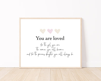 A little girl’s graphic showing three baby pink hearts with a piece of writing below that says: You are loved, for the girl you are, the woman you will become, and for the precious daughter you will always be.
