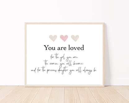 A little girl’s graphic showing three pink and beige hearts with a piece of writing below that says: You are loved, for the girl you are, the woman you will become, and for the precious daughter you will always be.