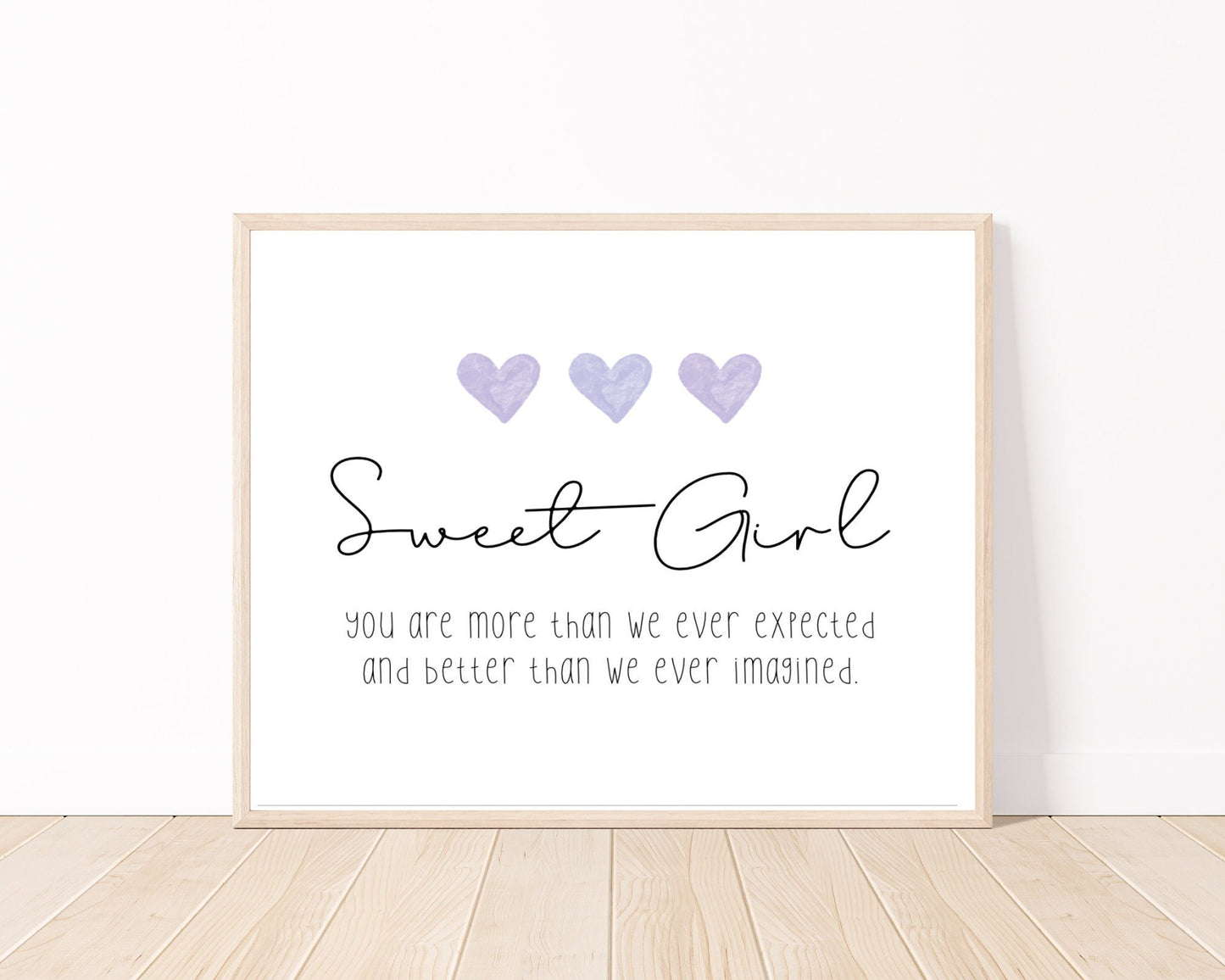 A little girl’s room digital print placed on a white wall and parquet flooring that has three purple hearts at the top, and a piece of writing that says: “Sweet girl, you are more than we ever expected and better than we ever imagined.”