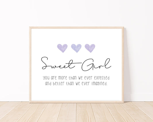 A little girl’s room digital print placed on a white wall and parquet flooring that has three purple hearts at the top, and a piece of writing that says: “Sweet girl, you are more than we ever expected and better than we ever imagined.”